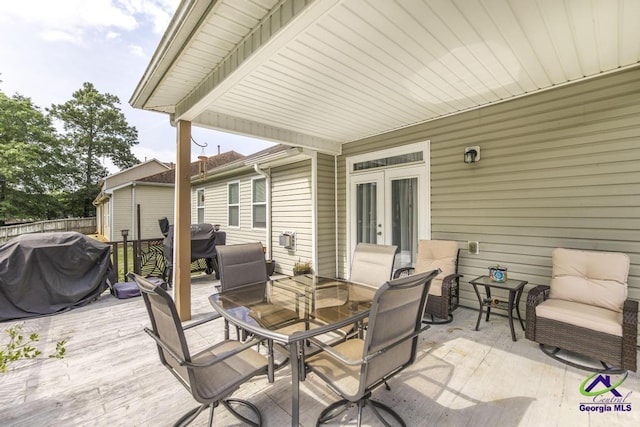view of patio / terrace with outdoor dining area, a wooden deck, area for grilling, and french doors