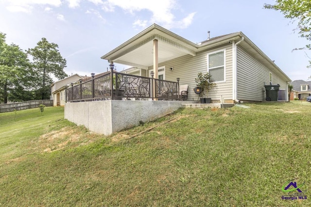 rear view of house with fence and a yard