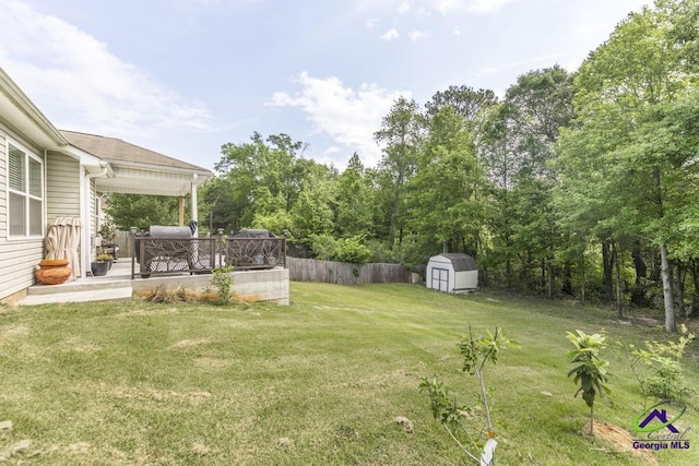 view of yard with a storage shed, an outbuilding, and fence