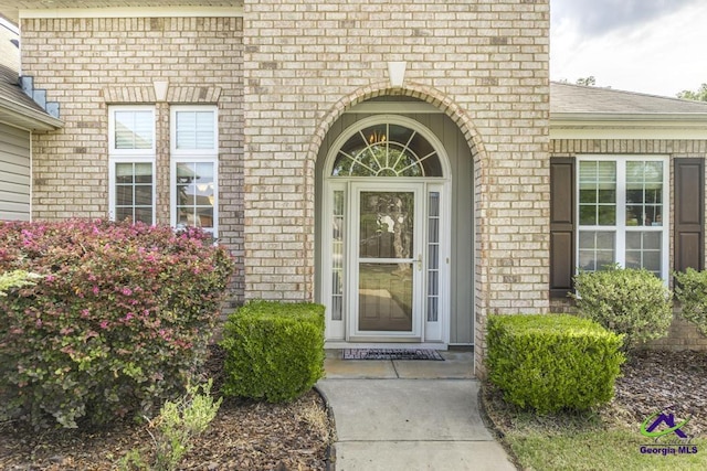 property entrance featuring brick siding