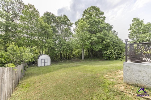 view of yard with an outdoor structure, fence, and a shed