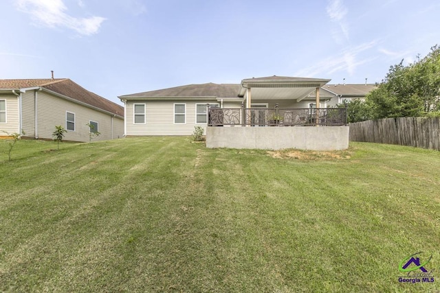back of house with fence and a lawn