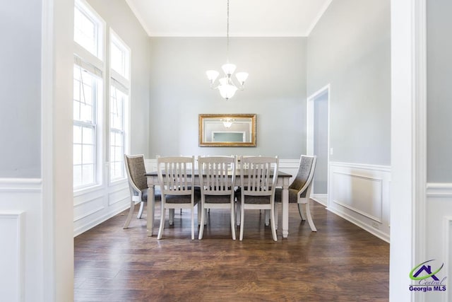 dining room with dark wood finished floors, a decorative wall, a healthy amount of sunlight, and a chandelier