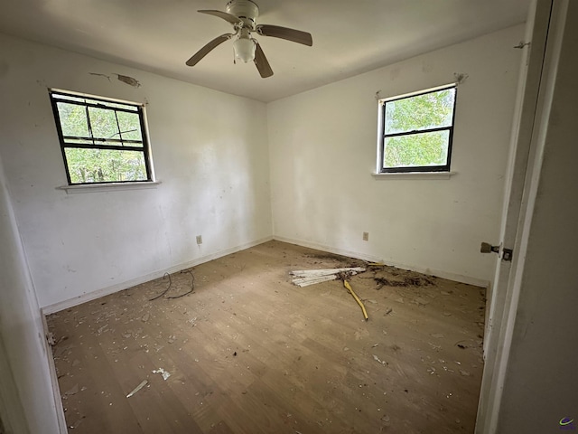 spare room with ceiling fan, baseboards, and wood finished floors