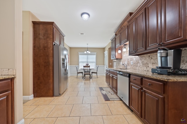 kitchen with stainless steel appliances, a sink, light tile patterned flooring, visible vents, and decorative backsplash