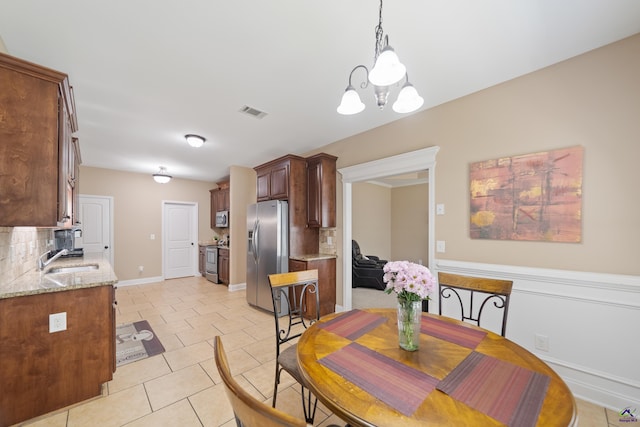 dining area featuring light tile patterned floors, an inviting chandelier, visible vents, and baseboards