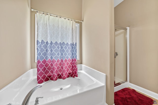 full bath with a bath and a shower stall