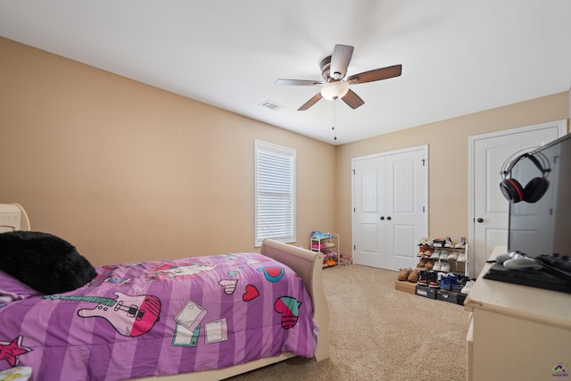carpeted bedroom featuring visible vents, a closet, and ceiling fan