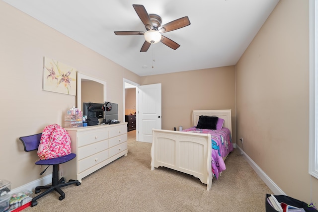 bedroom featuring light carpet, a ceiling fan, and baseboards