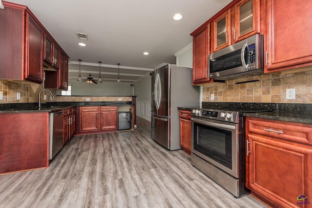 101 Bryce Dr, Warner Robins, GA 31088 - kitchen featuring appliances with stainless steel finishes, dark brown cabinets, light wood-style flooring, and crown molding