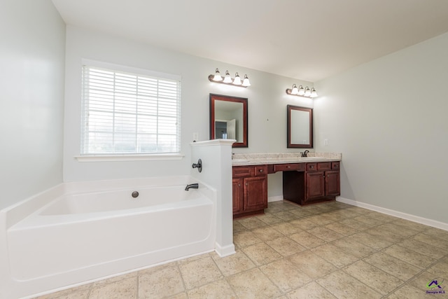 101 Bryce Dr, Warner Robins, GA 31088 - bathroom with double vanity, a garden tub, baseboards, and a sink