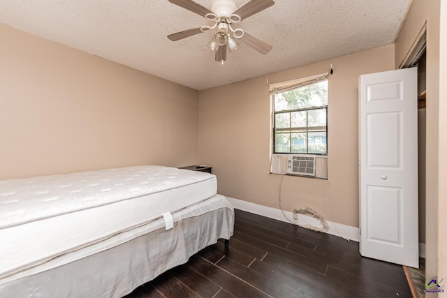 bedroom with a textured ceiling, dark wood finished floors, cooling unit, baseboards, and ceiling fan