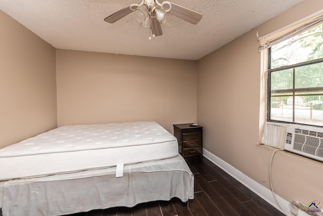 bedroom with wood finished floors, a textured ceiling, a ceiling fan, and baseboards