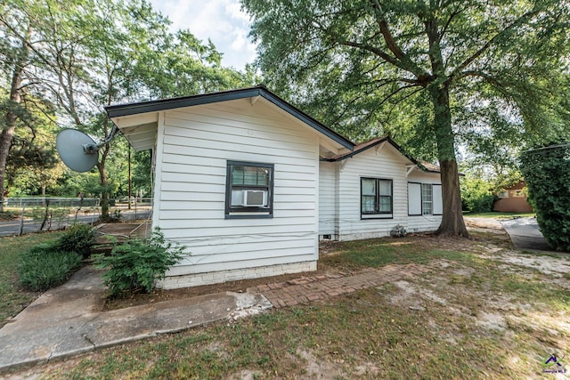 view of side of property featuring fence and cooling unit