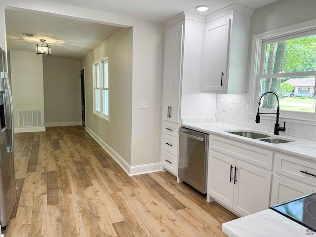 407 Frank Satterfield Rd, Perry, GA 31069 - kitchen featuring a sink, appliances with stainless steel finishes, backsplash, and white cabinets