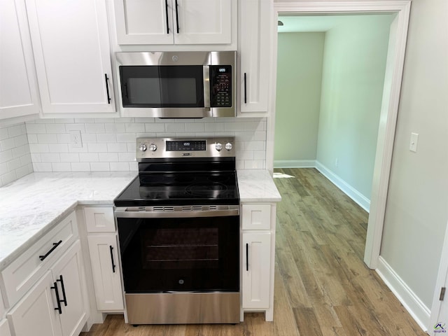 407 Frank Satterfield Rd, Perry, GA 31069 - kitchen featuring stainless steel appliances, white cabinetry, light wood-type flooring, and backsplash