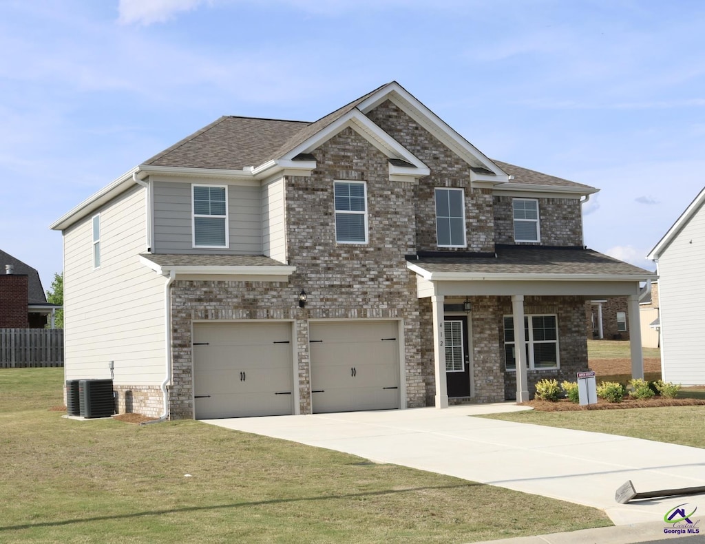 craftsman-style house featuring fence, driveway, central AC, a front yard, and an attached garage