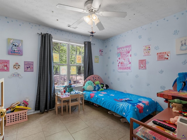 bedroom featuring visible vents, light tile patterned floors, ceiling fan, and a textured ceiling