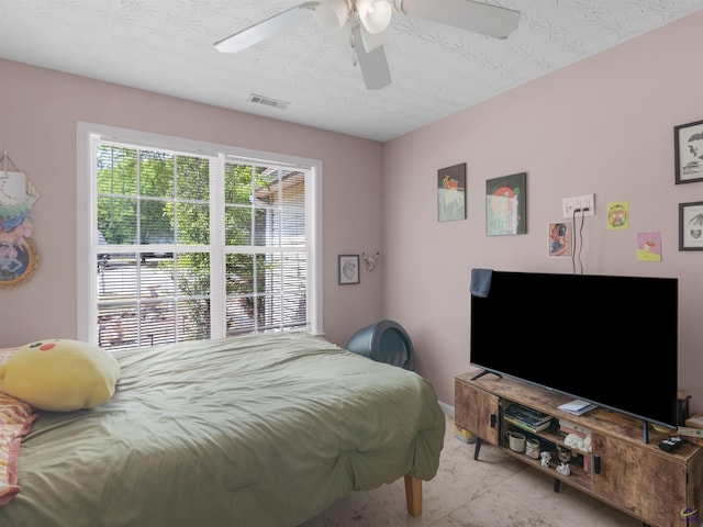 bedroom featuring visible vents, ceiling fan, and a textured ceiling