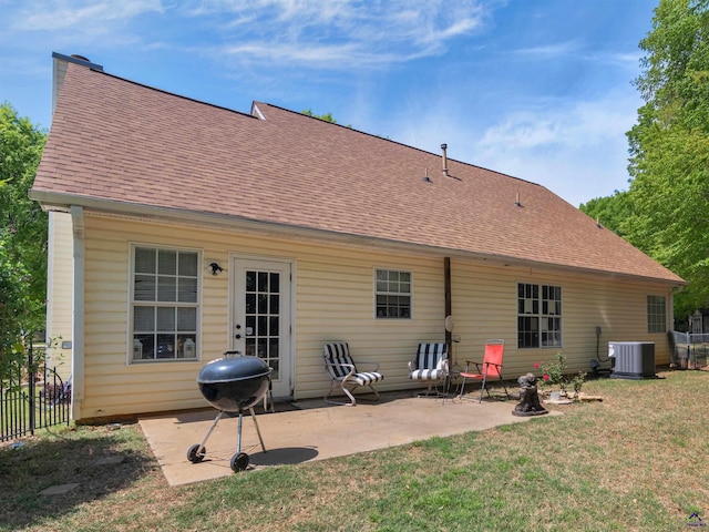 rear view of house featuring central air condition unit, a patio area, a lawn, roof with shingles, and fence