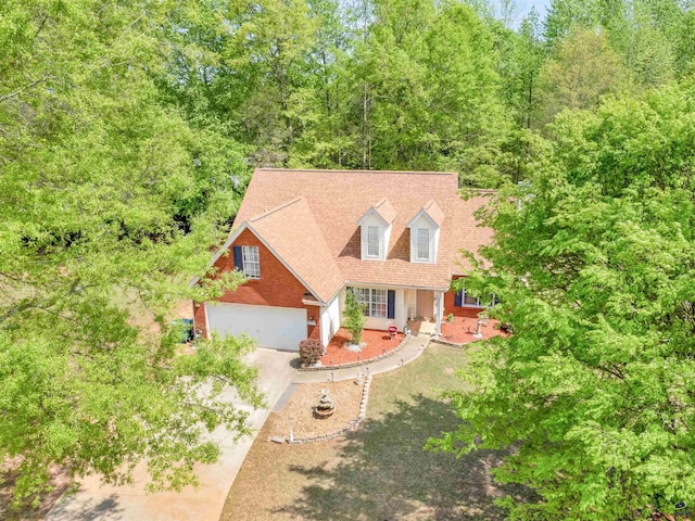 view of front of property with a garage, brick siding, driveway, and roof with shingles