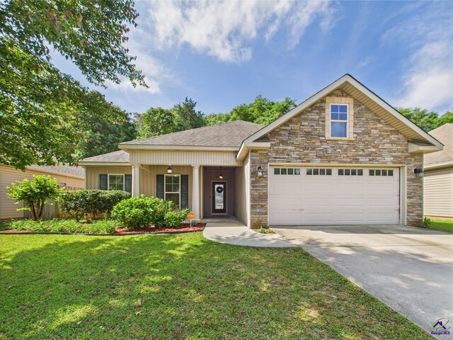 view of front facade featuring driveway, stone siding, roof with shingles, a front yard, and an attached garage