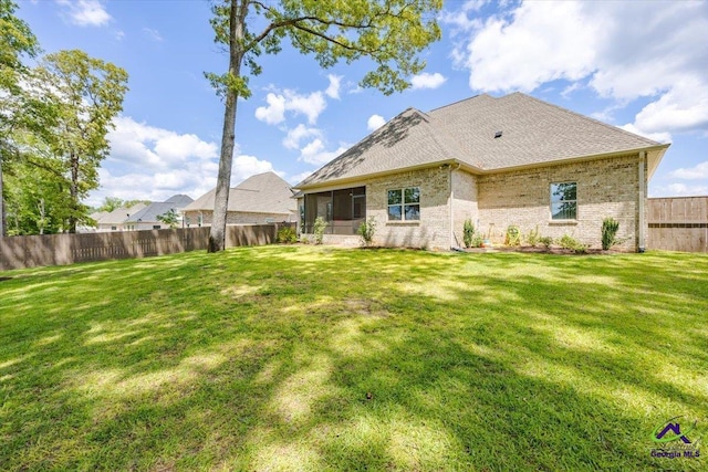 315 Apalachee Way, Bonaire, GA 31005 - back of house with brick siding, a fenced backyard, a yard, and a sunroom