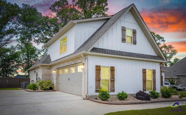 315 Apalachee Way, Bonaire, GA 31005 - property exterior at dusk with a shingled roof, a garage, driveway, board and batten siding, and fence