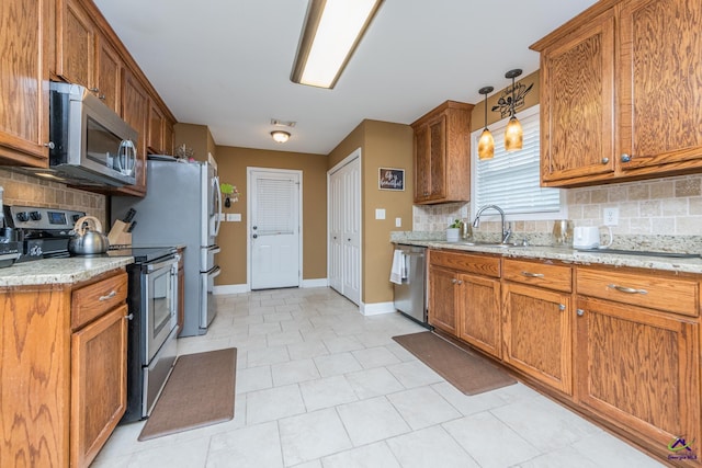 105 Taconic Ct, Bonaire, GA 31005 - kitchen featuring tasteful backsplash, a sink, appliances with stainless steel finishes, baseboards, and brown cabinetry