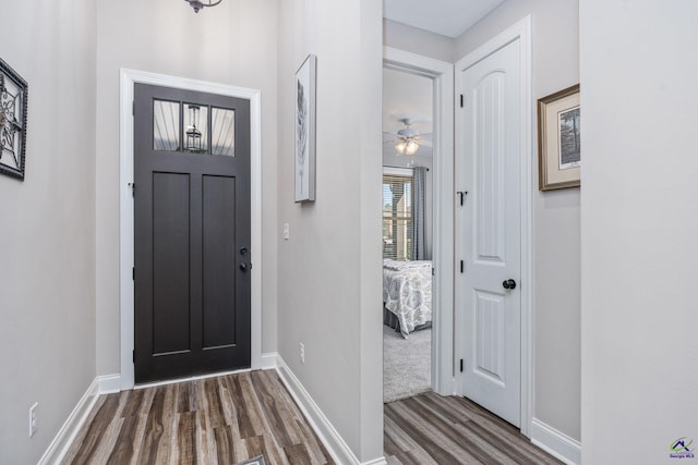 entrance foyer with baseboards, ceiling fan, and dark wood-type flooring