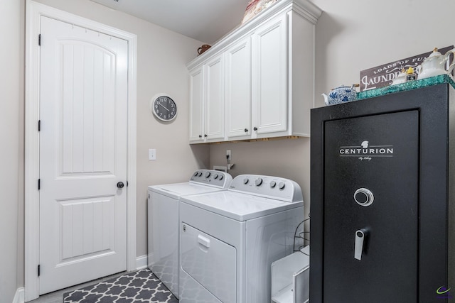 clothes washing area featuring washer and dryer, cabinet space, and baseboards