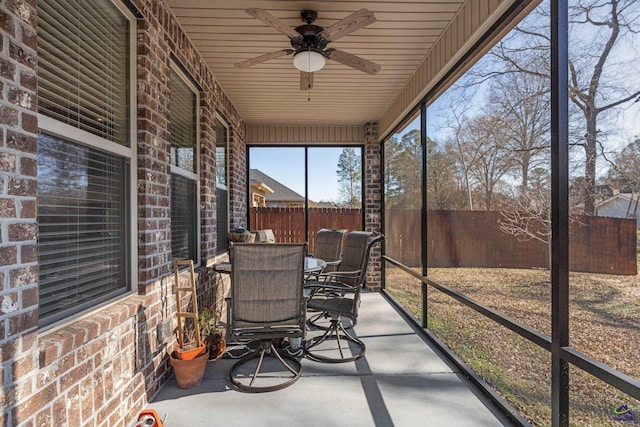 sunroom / solarium with a ceiling fan and outdoor dining area