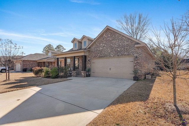 traditional-style house featuring a garage, brick siding, covered porch, and driveway