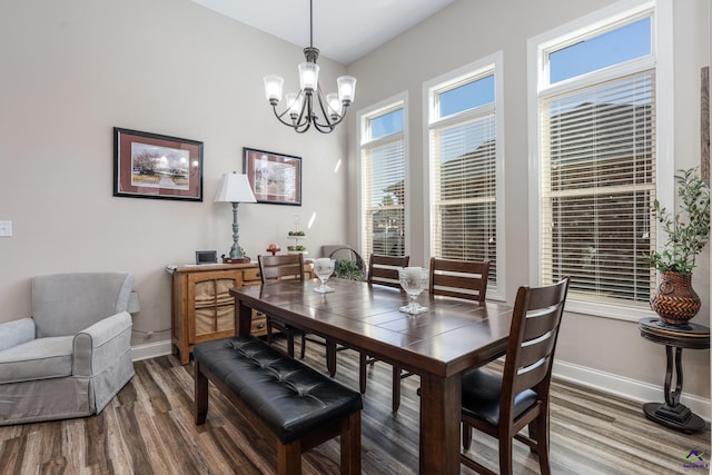 dining space with an inviting chandelier, wood finished floors, and baseboards