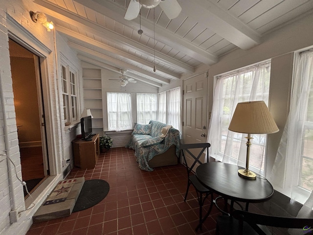 sunroom with vaulted ceiling with beams, a ceiling fan, tile patterned flooring, and wooden ceiling