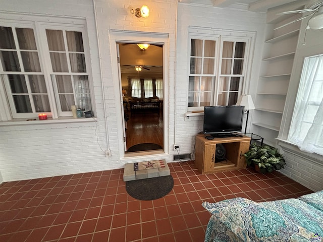 entrance to property with a ceiling fan and visible vents