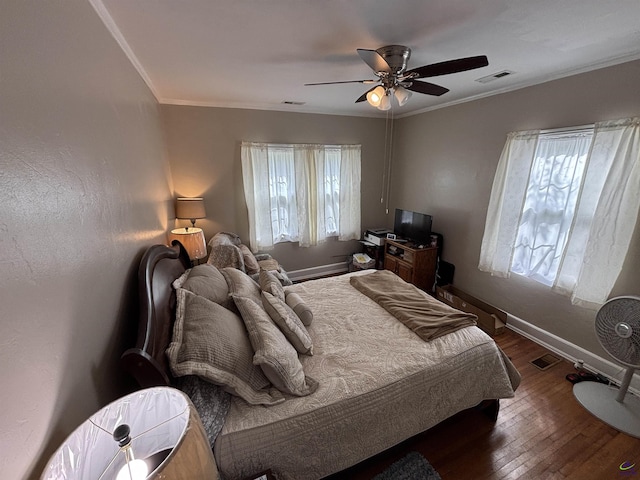 bedroom featuring baseboards, ornamental molding, wood finished floors, and visible vents