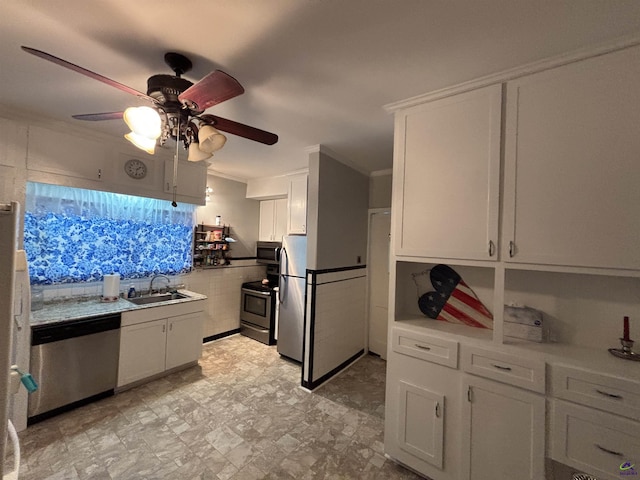 kitchen featuring ceiling fan, crown molding, a sink, white cabinets, and stainless steel appliances