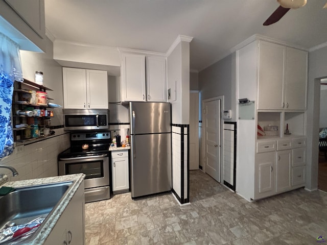 kitchen with a ceiling fan, appliances with stainless steel finishes, a sink, light countertops, and white cabinets