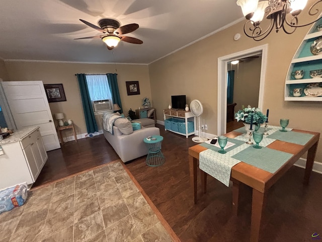 living room featuring baseboards, ornamental molding, ceiling fan with notable chandelier, and wood finished floors