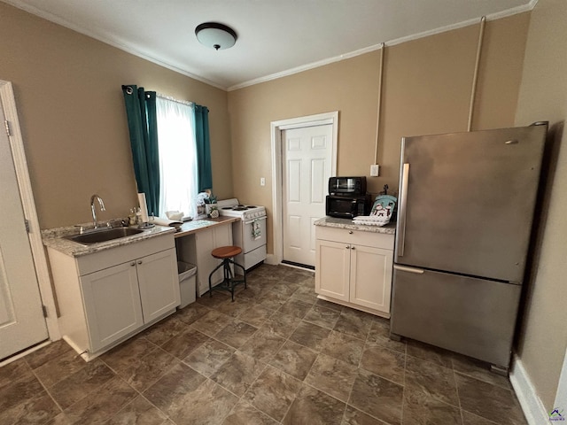 kitchen featuring white range oven, freestanding refrigerator, ornamental molding, white cabinets, and a sink