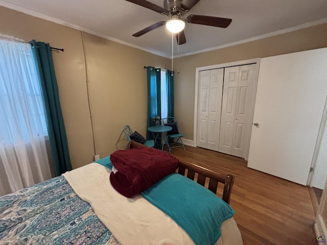 bedroom featuring ceiling fan, ornamental molding, wood finished floors, and a closet