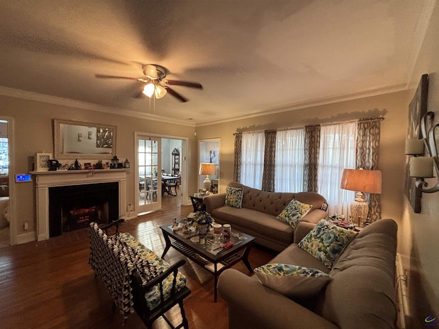 living room with ornamental molding, a fireplace, a ceiling fan, and wood finished floors