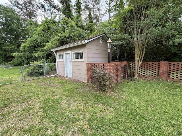view of outbuilding with a gate, fence, and an outbuilding