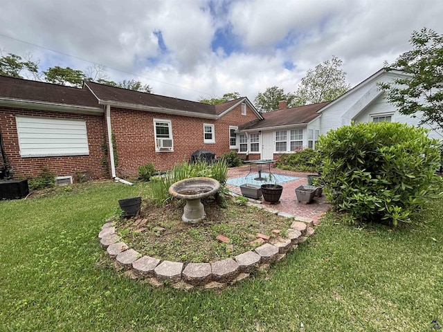 back of property featuring a yard, brick siding, and central AC unit