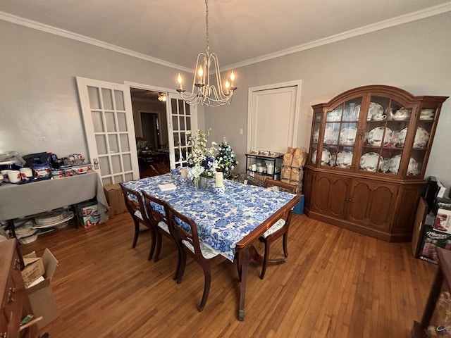 dining room with an inviting chandelier, ornamental molding, french doors, and light wood-type flooring