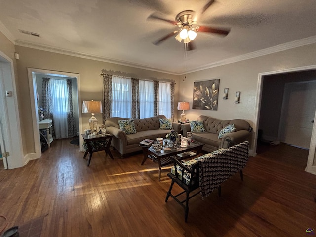 living area with wood-type flooring, ornamental molding, ceiling fan, and visible vents
