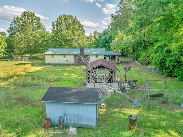 back of house with a storage unit, an outdoor structure, board and batten siding, and fence
