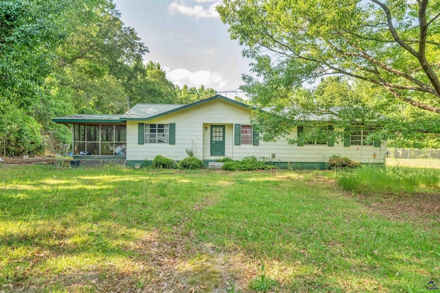 view of front of property with a sunroom and a front yard
