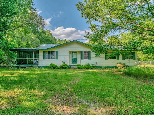 view of front of home featuring a sunroom and a front lawn